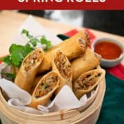 A Pinterest image of spring rolls cut in half in a steamer basket.