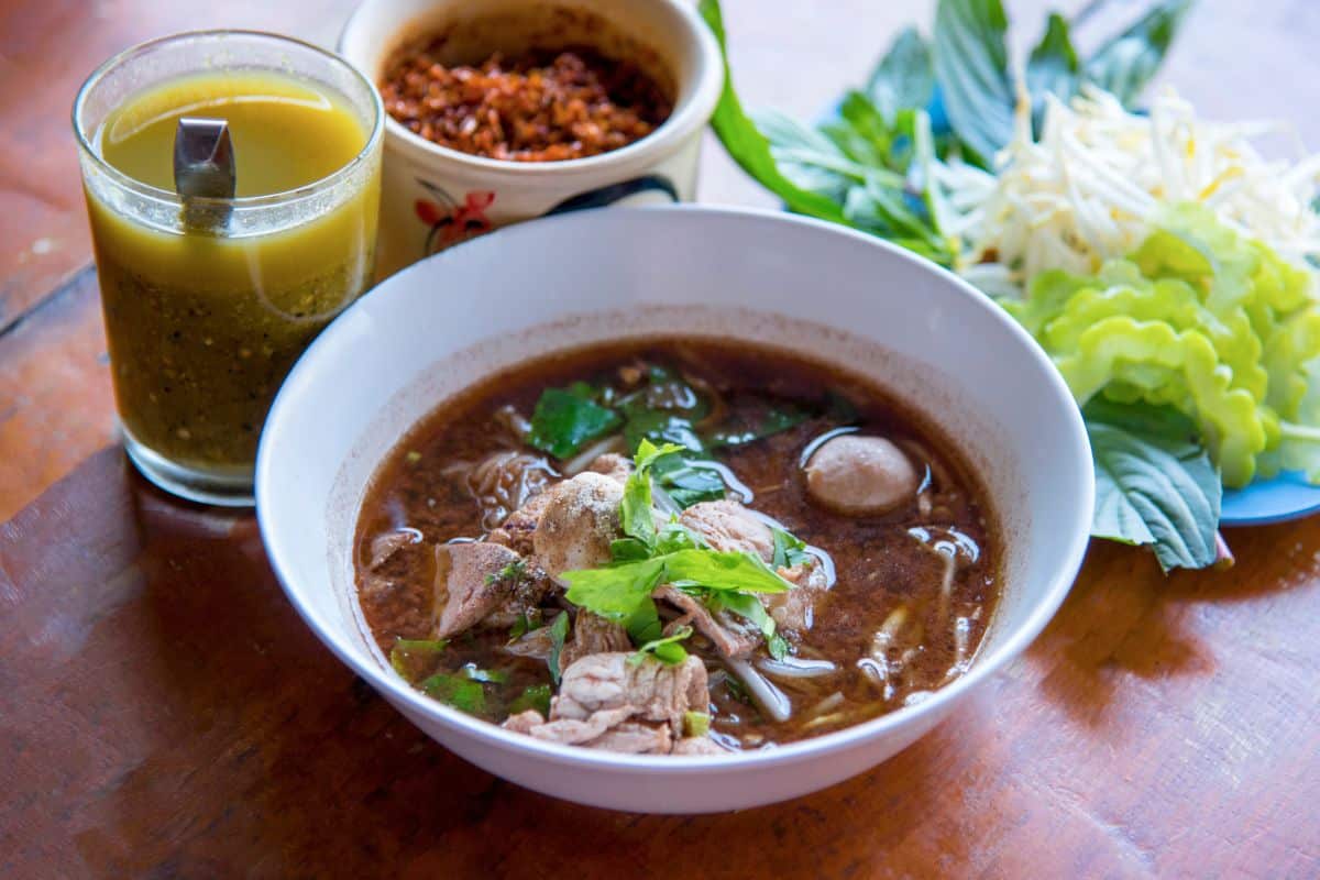 Thai boat noodles with condiments and side vegetables