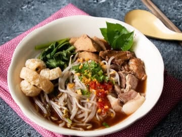 a bowl of boat noodles on pink napkin
