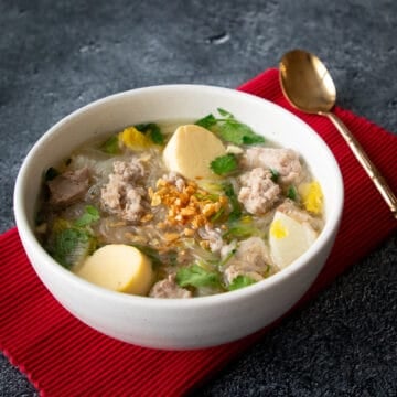 A bowl of thai glass noodle soup with egg tofu