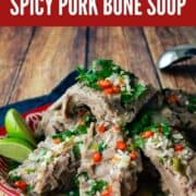 A platter of pork bones in broth. With text overlay "Thai street food spicy pork bone soup"