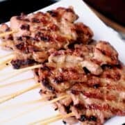a plate of pork skewers