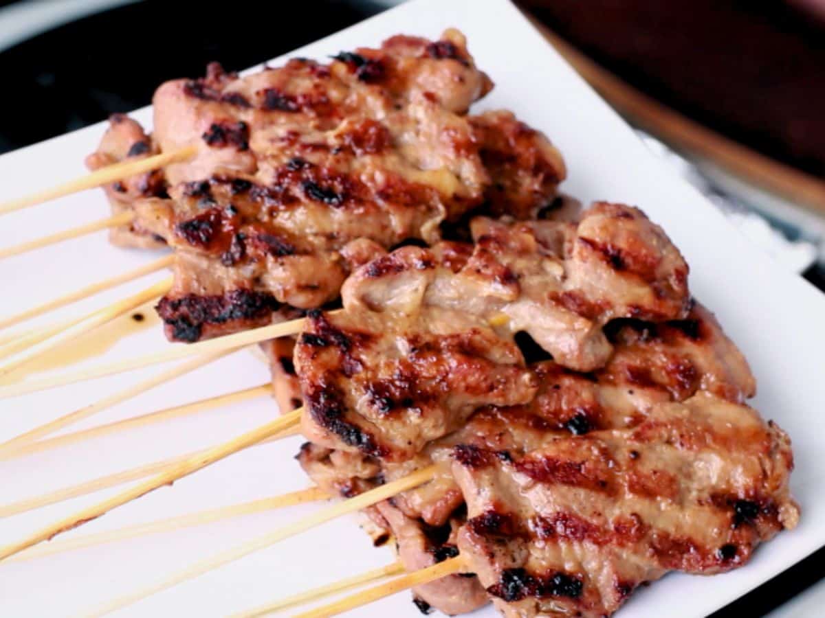 a plate of pork skewers