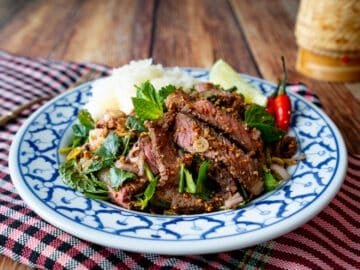 A plate of Thai grilled steak salad with sticky rice - nam tok neua