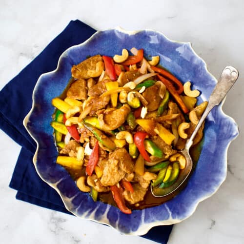 Sweet and sour pork in a blue plate on blue napkin