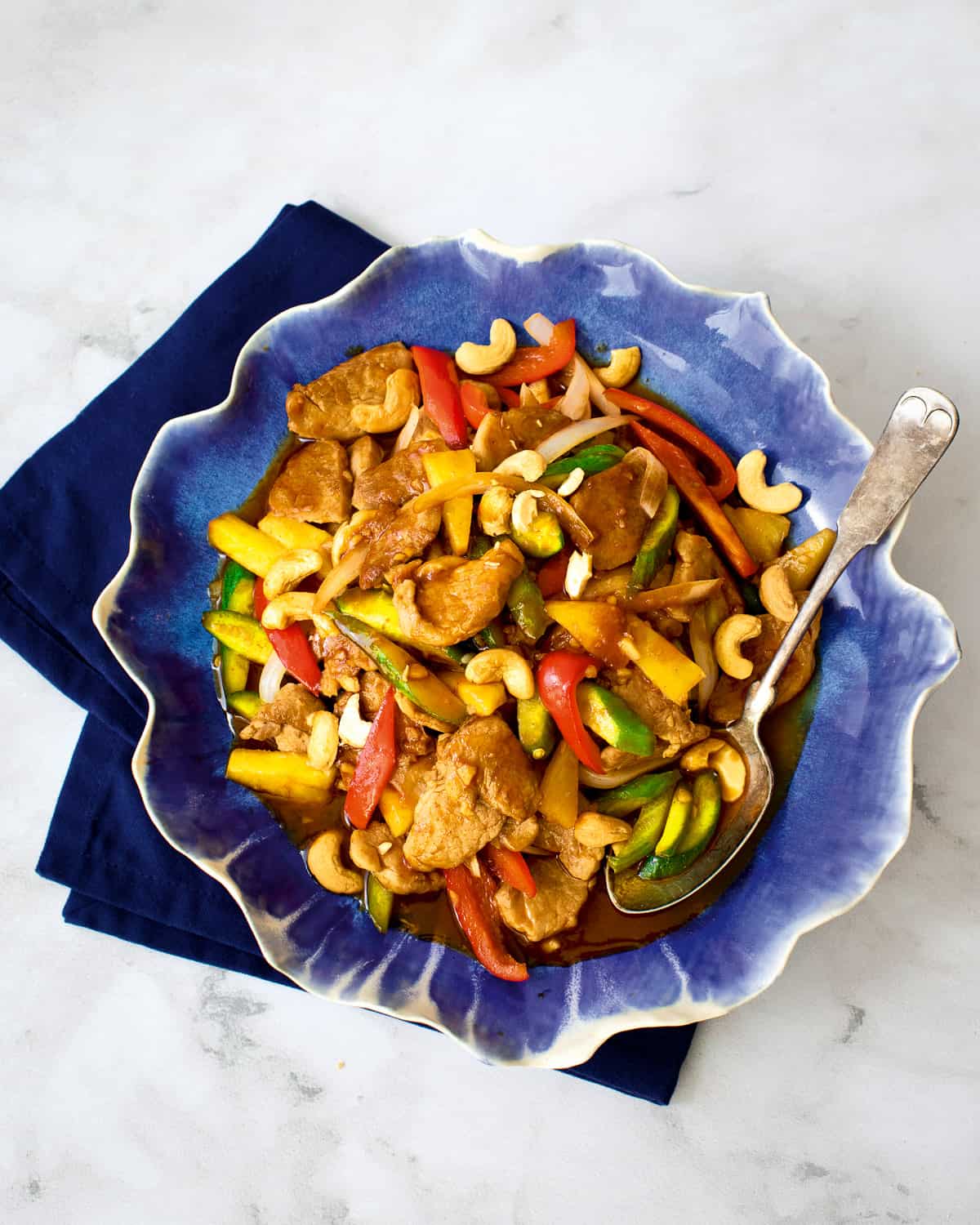 Sweet and sour pork in a blue plate on blue napkin