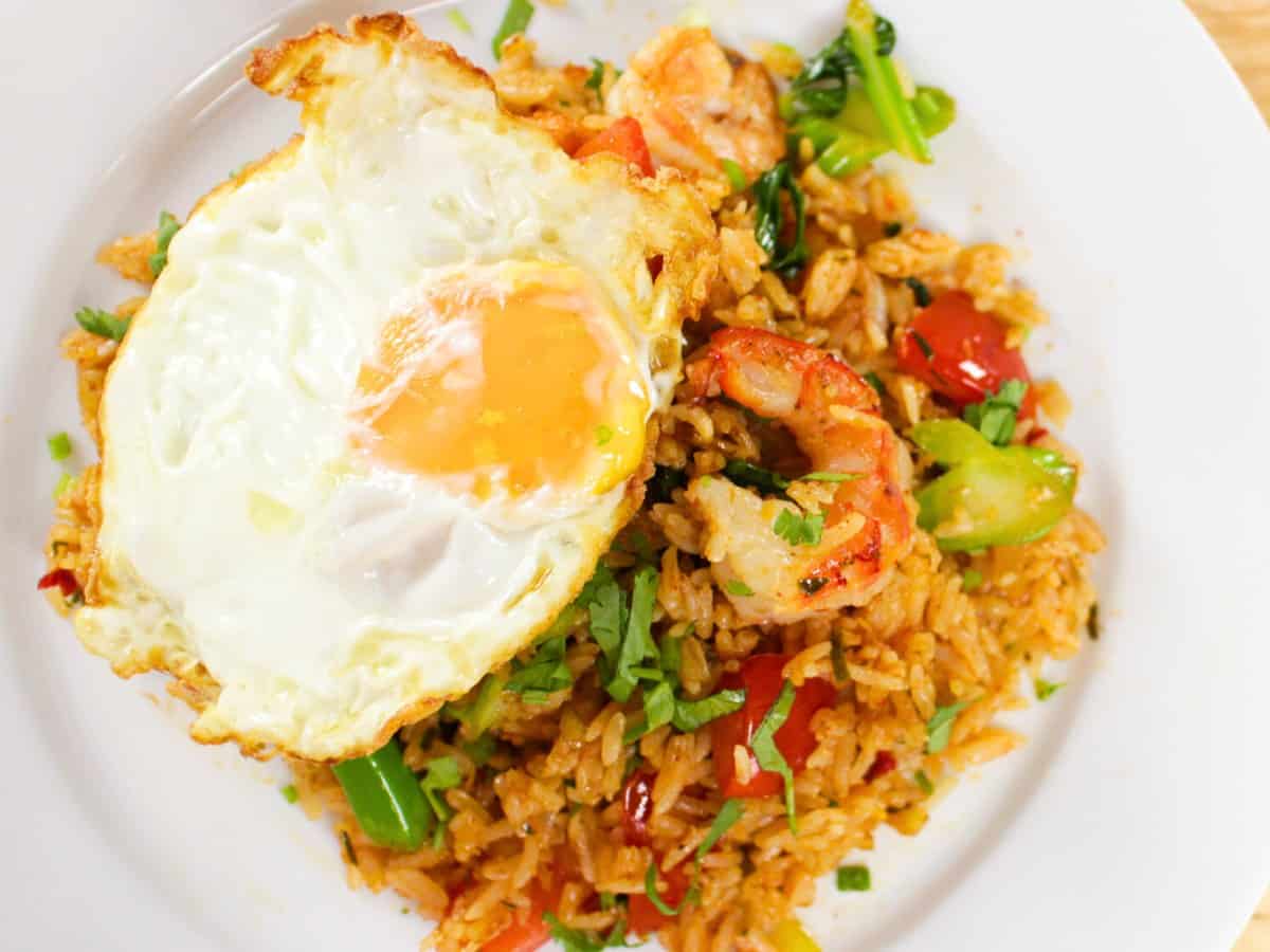 a plate of tom yum fried rice with a shrimp on top