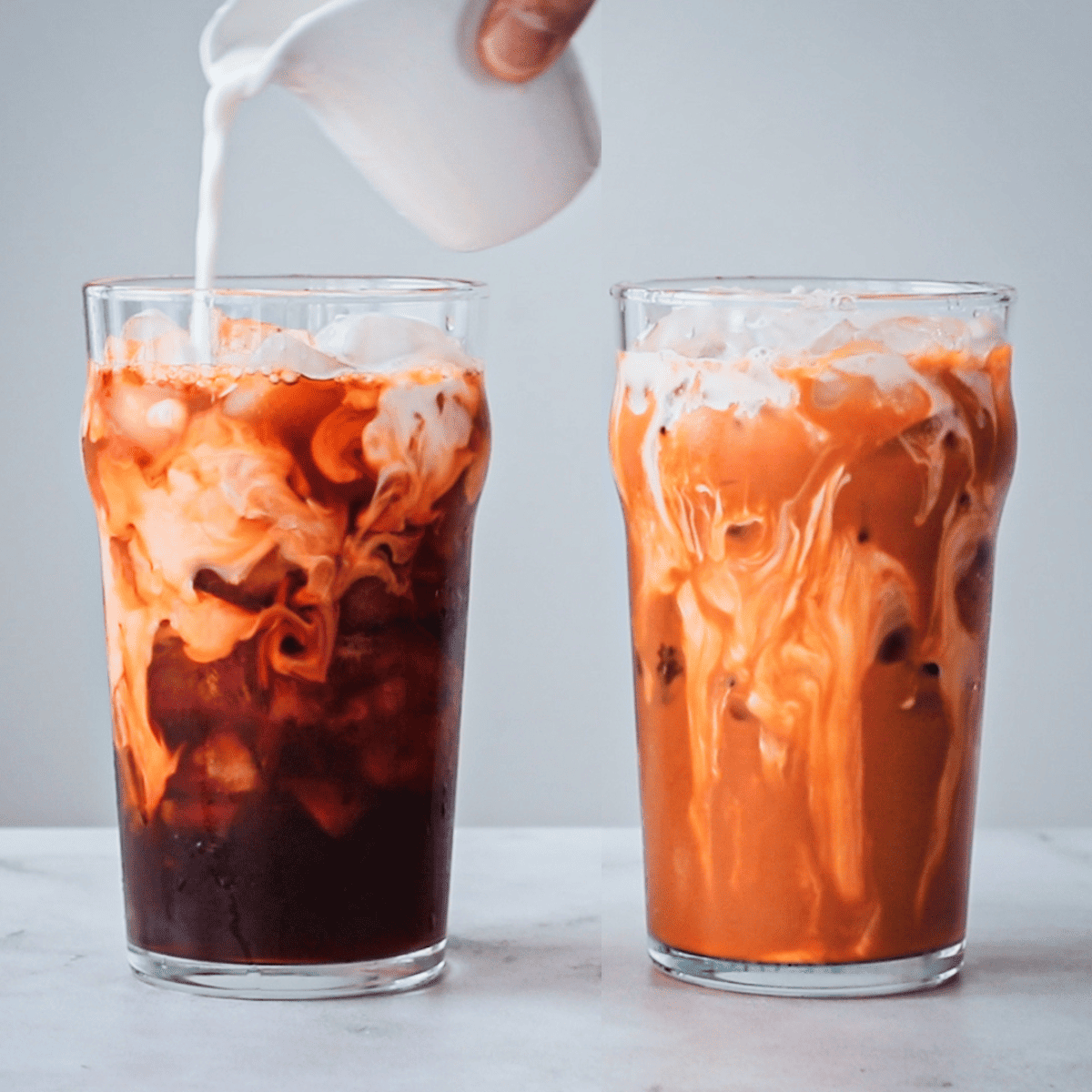 Two glasses of Thai tea, one with half and half being poured into it.